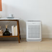 Levoit smart air purifier with front vent grille and top controls, white body on floor