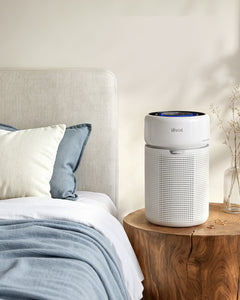 White cylindrical air purifier with blue-lit top display and perforated grille